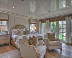 a bedroom with white furniture and wood floors