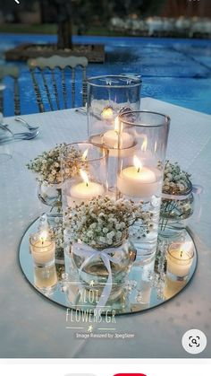 the table is set with candles and flowers in glass vases on top of it