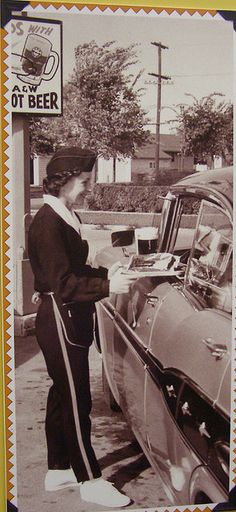 an old black and white photo of a woman filling up her car