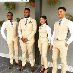 three men and two women in tan suits standing next to each other on a tile floor