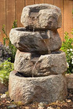 a rock fountain in the middle of a garden