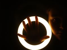 a person holding up a glowing ring in the dark