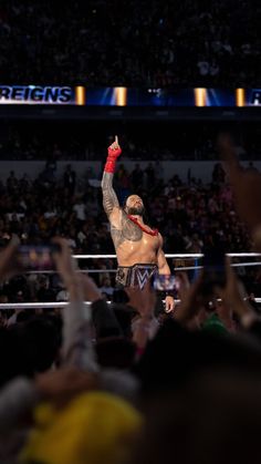 the wrestler is holding his arm up in victory