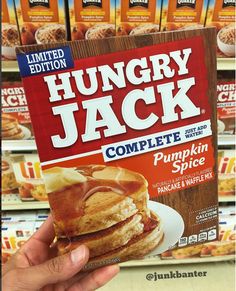 a hand holding up a box of hungry jack complete with pumpkin spice and maple syrup