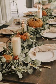 a long table with plates and candles on it