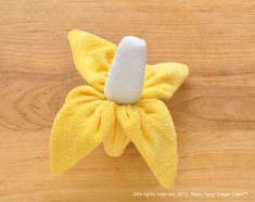 a yellow flower with a white center on a wooden surface