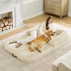 a woman laying on top of a dog bed