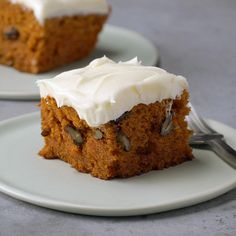 two pieces of carrot cake with frosting on plates