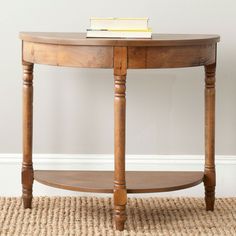 a table with a book on top of it in front of a wall and rug