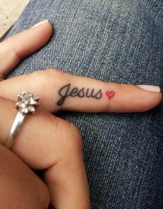 a woman's hand with a small tattoo that says jesus on the middle finger