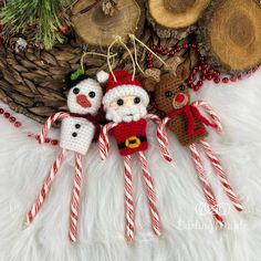 three christmas ornaments are hanging on a white furnishing with red and green candy canes