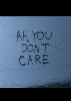 graffiti written on the side of a wall that says ah you don't care