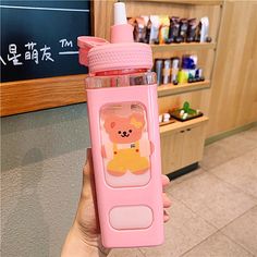 a person holding a pink water bottle with a bear on it