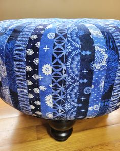 a foot stool covered in strips of blue fabric