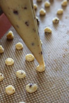 a cookie being made with doughnut holes on a baking sheet and an object in the background