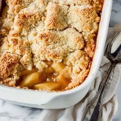 a casserole dish filled with apples and crumbs