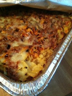 a casserole dish with meat, cheese and sauce in it sitting on a table