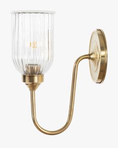 a wall light with a glass shade on it's side and a gold arm