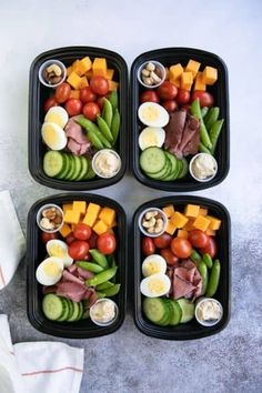 four plastic trays filled with different types of vegetables and meat on top of each other