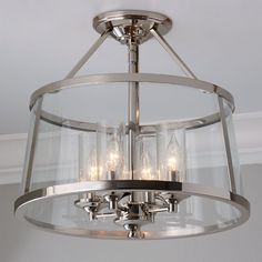 a chandelier hanging from the ceiling with clear glass and metal fixtures on it