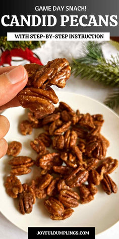 a white plate topped with pecans next to a hand holding a piece of pecan