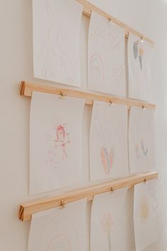 several children's drawings are hanging on the wall