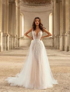 a woman in a wedding dress posing for the camera with her hands on her hips