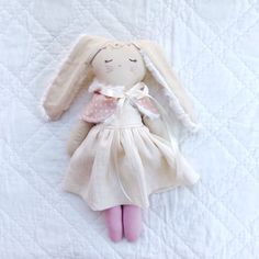 a stuffed bunny doll laying on top of a bed