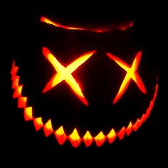 a jack o lantern with two crosses carved on it's face, lit up in the dark