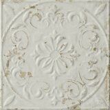 an old white tile with floral designs on the center and bottom part of it's surface