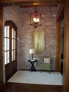 a living room with brick walls and white carpet