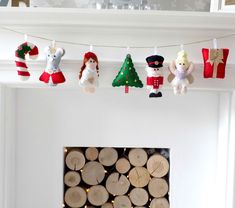 christmas decorations hanging from clothes line over fireplace with fire place and logs in foreground