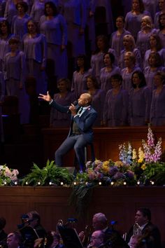 a man standing on top of a stage in front of a crowd