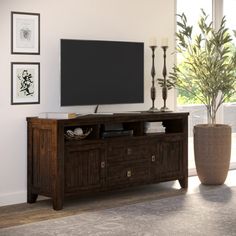 a large flat screen tv mounted to the side of a wooden entertainment center in a living room