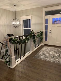 a staircase decorated for christmas with garland and lights hanging from the bannister rail