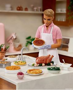 a barbie doll holding a turkey on top of a kitchen counter next to other food items