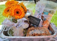 a basket filled with cookies and flowers sitting on top of a table in the grass