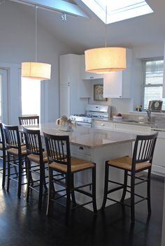 a kitchen with an island and four chairs in it, along with a breakfast nook