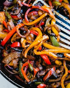 a skillet filled with stir fry vegetables and meat