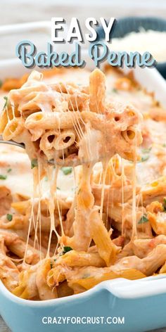 a blue casserole dish filled with pasta and cheese being lifted from the casserole