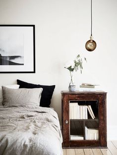 a bedroom with white walls and wooden floors