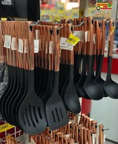 black and silver utensils hanging from hooks in a store