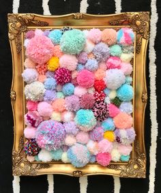 a gold frame filled with pom - poms