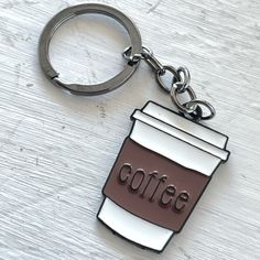 a coffee cup shaped keychain with the word coffee on it's side