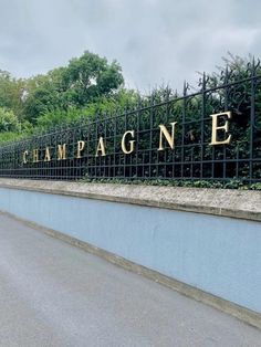 there is a sign that says champagne on the side of the road in front of a fence