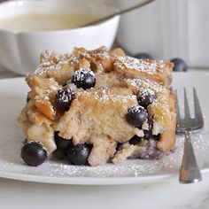 a close up of a plate of food with blueberries and powdered sugar on it