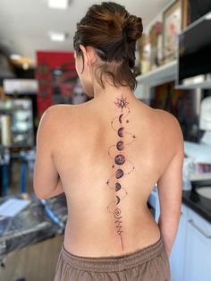 the back of a woman's neck with tattoos on her upper and lower back