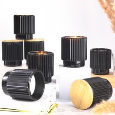 several black candle holders sitting next to each other on top of a white table with gold accents