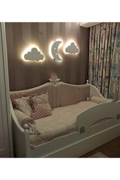 a baby's room with a crib and lights on the wall above it