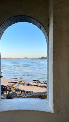 an arched window looking out at the ocean